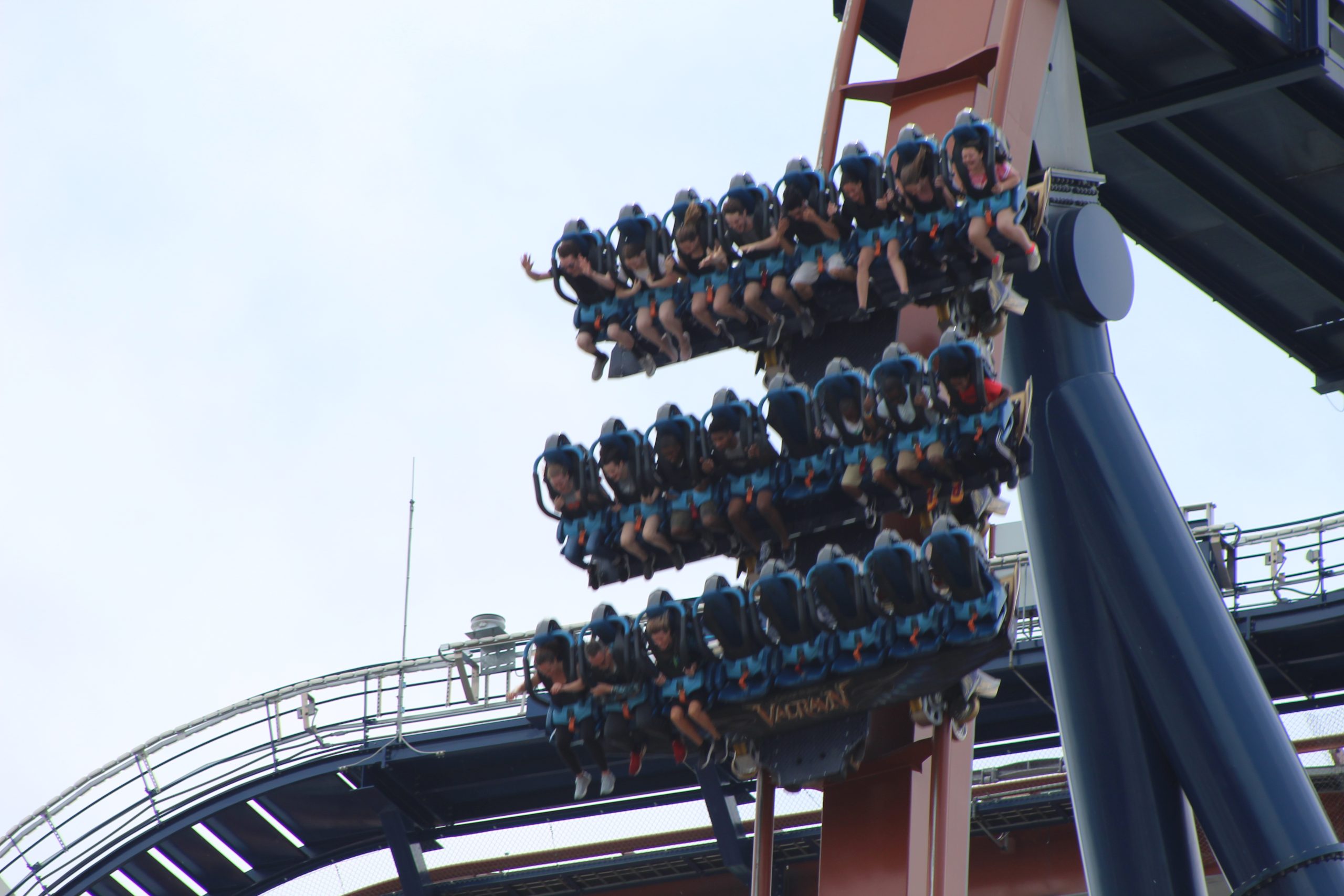 roller coaster with people on dropping on dive