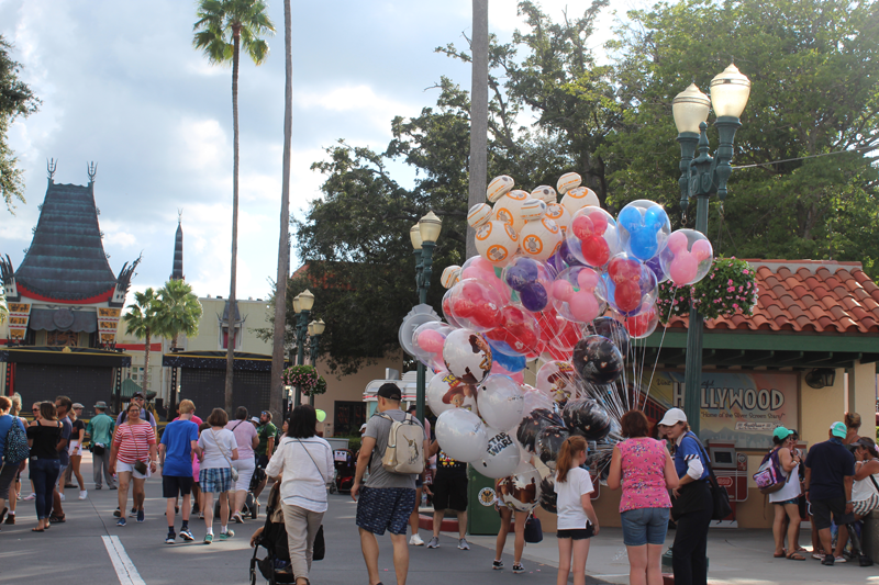 Crowd at disney hollywood featuring a person with a lot of balloons