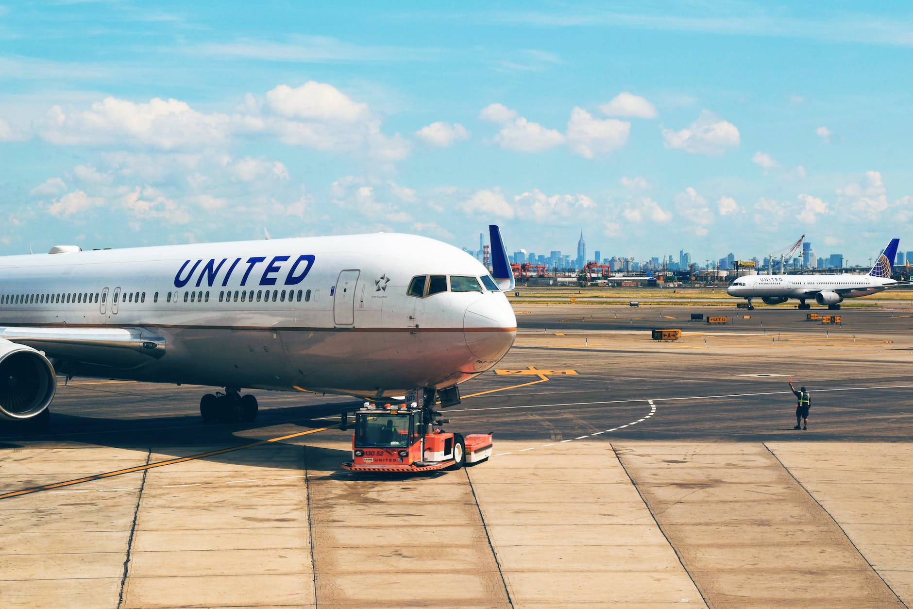 white airplane near man in green vest